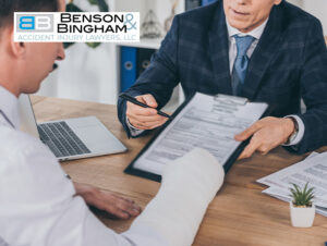 Attorney discussing a settlement check with a client in a cast