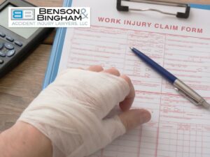Injured hand filling out work injury form – Workers' Compensation claim.