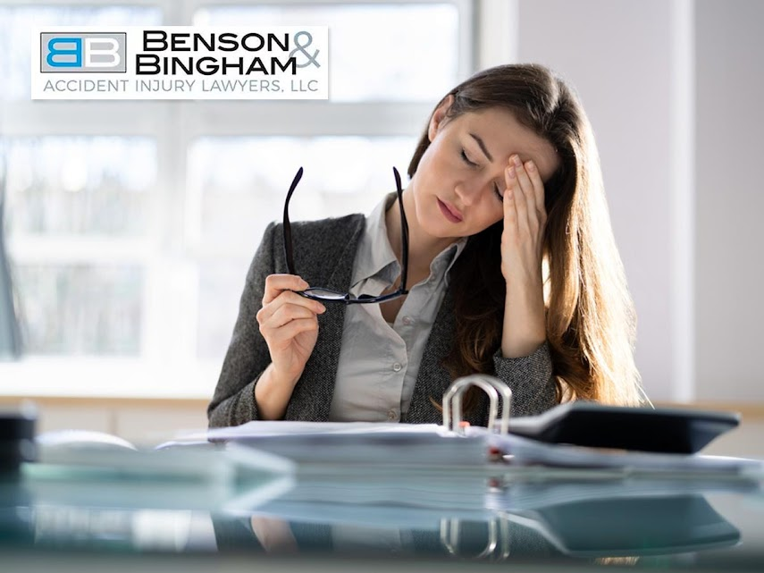 Woman feeling overwhelmed at her desk due to job-related stress