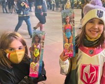 Two Girls Holding Barbie Dolls