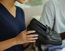 Volunteer Holding Black Oxford Shoes