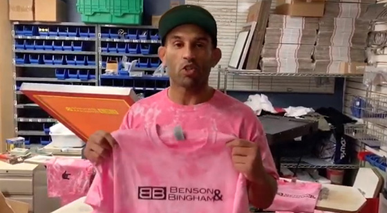 Volunteer At The Kar.ma Project Holding Pink Shirt With B&B logo For Cancer Awareness Month