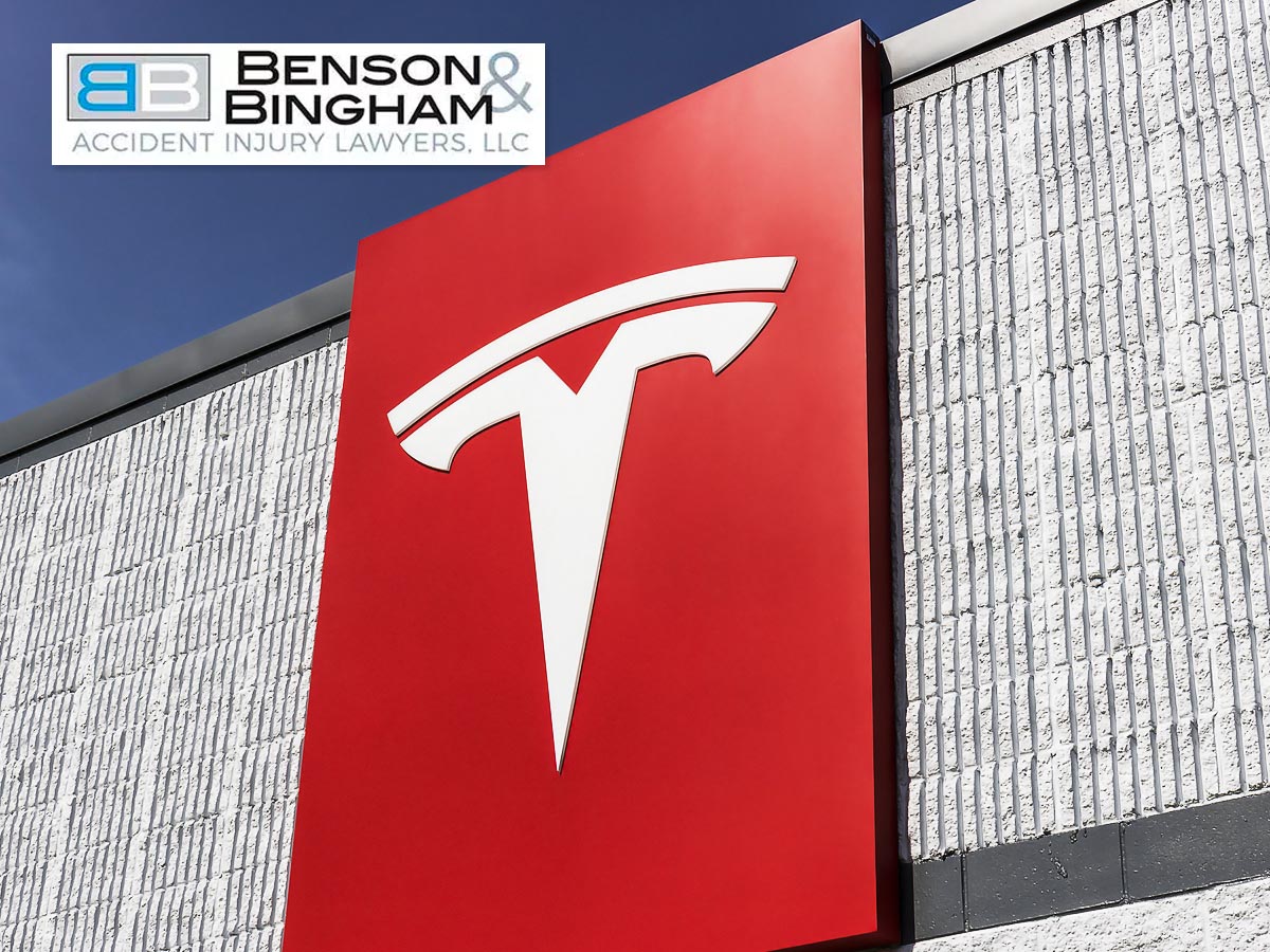 Tesla logo on a large red sign mounted on a building wall
